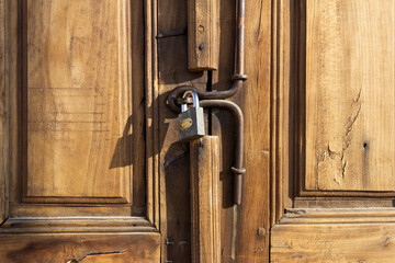 Rustic wooden door with traditional iron latch and padlock in Yazd, Iran — showcasing Persian craftsmanship and architectural heritage.