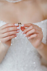 Bridal preparations with a close-up of the wedding ring in white dress