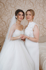 Bride and mother share a heartfelt moment before the wedding ceremony in elegant attire