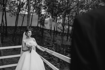 Bride posing on balcony surrounded by trees during wedding ceremony