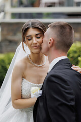 Couple shares a tender moment during outdoor wedding ceremony in lush garden setting