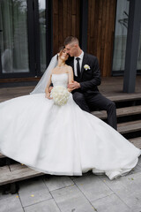 Couple shares a romantic moment outdoors on their wedding day with a beautiful dress and suit