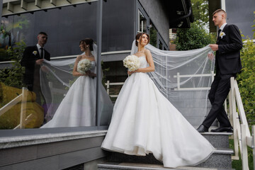Elegant bride and groom pose outside a modern venue on their wedding day