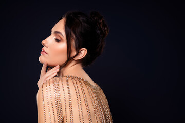 Sensual brunette woman adorned with luxurious sparkling embellishments against a dark background