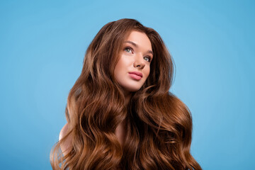Portrait of a young woman with long wavy brown hair, showcasing beauty, fashion, and healthy haircare