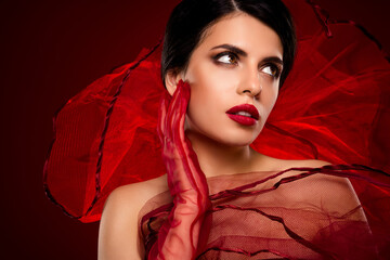 Beautiful young brunette woman in red attire posing with elegance and charm, showcasing sophisticated beauty