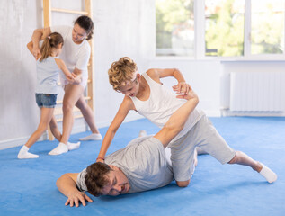 Parent and child train and perform basic punches and creases during self-defense lesson. Parent...