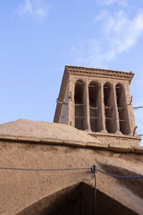Historic windcatcher in Yazd, Iran, stands tall against a vivid blue sky—an iconic example of ancient Persian architecture and sustainable design.