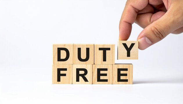 A hand carefully positioning the letter Y to complete the DUTY FREE block letters, symbolizing the removal of taxes on goods