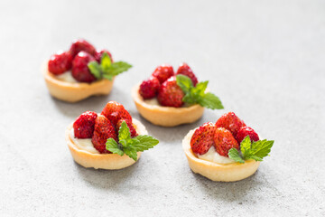 Mini strawberry tartlet. Light gray background. Close up