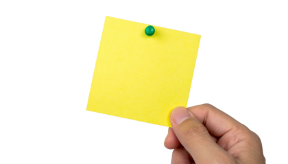 A hand holding a yellow sticky note, ready to jot down ideas. The note is pinned with a green pin