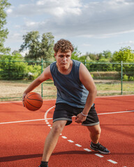 young man player dribbling ball on basketball court