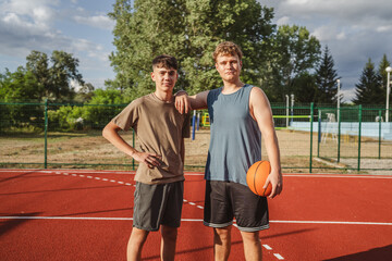 Friends basketball teenage players stand on the court with ball