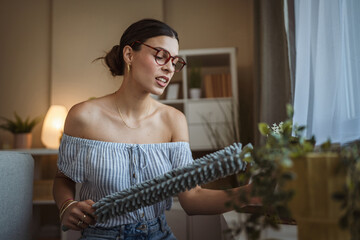 adult woman meticulously cleans dust from furniture in the living room