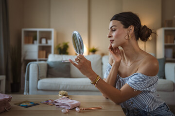 Smiling relaxed dark haired woman making anti-aging face massage