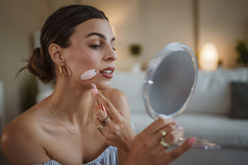 woman use facial massage tool at home and enjoy at time for herself