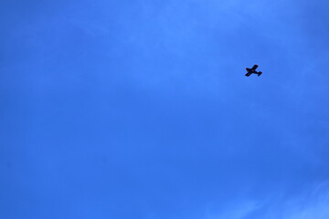 Airplane soaring through a vibrant blue sky on a bright sunny day