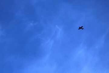 Airplane soaring through a vibrant blue sky on a bright sunny day
