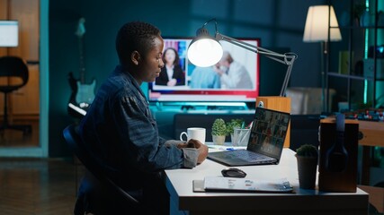 Remote worker greeting colleagues during business meeting on videocall in apartment office. Self...