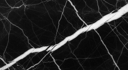 Close-up of black marble texture with prominent white veins running diagonally and horizontally across the surface.