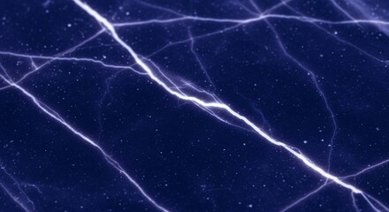 Close-up view of cracked ice surface showing a network of white fracture lines against a dark blue background.