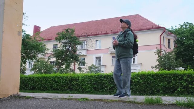 Sporty female tourist walking through city landmarks and photographing attractions with smartphone, solo travel lifestyle in 4K.