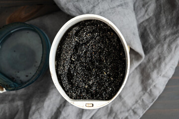 Ground Black Sesame Seeds in an Electric Spice Grinder: Powdered black sesame seeds in a coffee grinder viewed from directly above