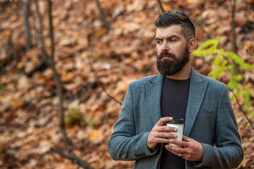 Coffee break. Everyday style routine. Bearded man having coffee in autumn city. Fall man in park...
