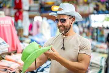 Man shopping fashion hat. Stylish man in boutique. Mature man choosing hat. Male accessories store....