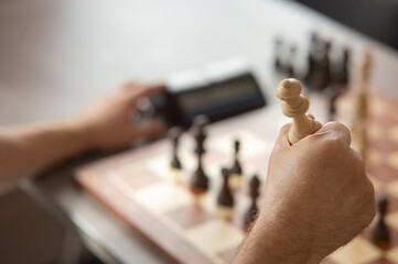 Close up of hands of middle aged caucasian man playing chess. 