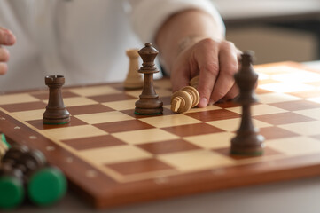Close up of hands of middle aged caucasian man playing chess. 