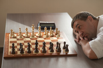 Middle aged Caucasian man playing chess. 