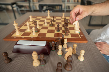 Close up of hands of middle aged caucasian man playing chess. 