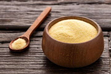 Coarse wheat semolina flour in a spoon and bowl - Triticum