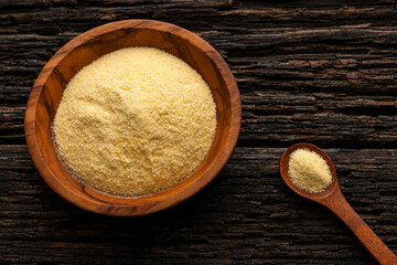 Coarse wheat semolina flour in a bowl and wooden spoon - Triticum