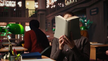 Older woman paying attention to reading hobby at the public library, enjoying storytelling for leisure in her free time. Relaxed mature person with wisdom and skill, literature. Camera A.