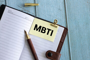 MBTI acronym, word on wood blocks on desk with books.