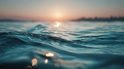 A serene ocean scene at sunset with gentle waves reflecting the warm glow of the sun on the horizon.