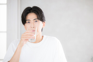 朝に水を飲む男性　水分補給などのクローズアップ