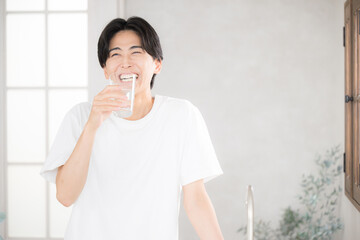 朝に水を飲む男性