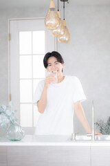 朝に水を飲む男性　水分補給など
