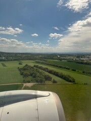 Blue sky with clouds over beautiful landscape, view through airplane window