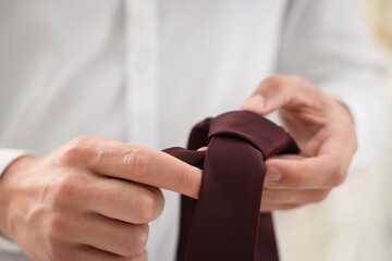 Man with stylish brown necktie at home, closeup