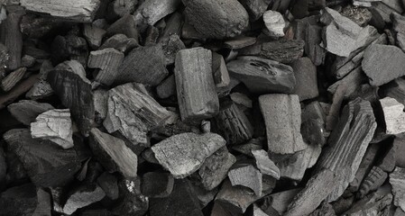 Pieces of black coals as background, top view