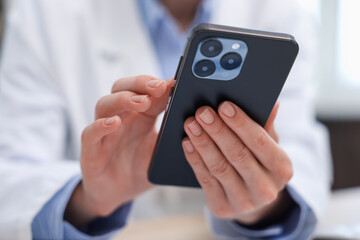 Doctor with smartphone in clinic, closeup. Online medical consultation