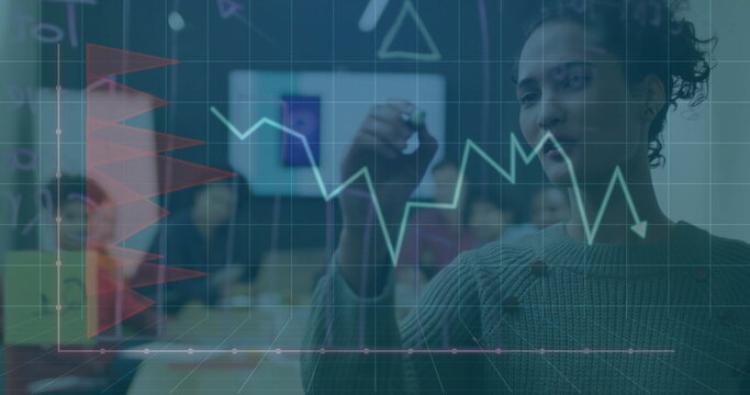 Female business analyst drawing graph on board at conference room, with open laptops, copy space