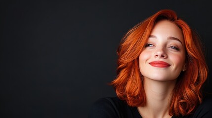 Bold crimson hair and tattooed beauty shines against dark grunge backdrop