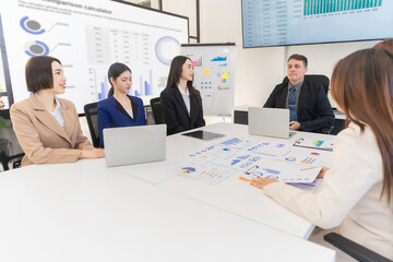 Group of Asian businessmen are analyzing charts and graphs during productive meeting, demonstrating teamwork and collaboration, financial business concept.