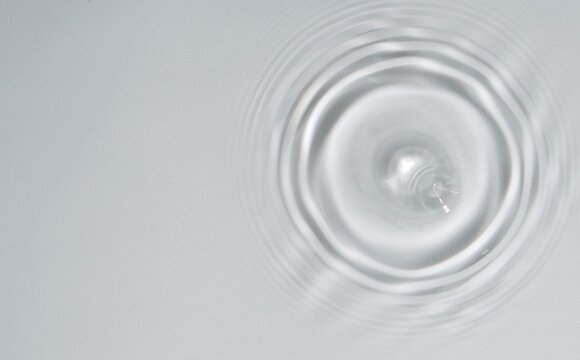 Water drop Ripple Flow sunlight top view transparent clear water white background. Circle wave water surface texture ripples, bubble, splashes. - Powered by Adobe