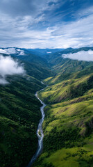 An aerial view of a winding river flowing through a lush green mountain valley